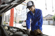 ボンネットを開けて車の整備する男性店員