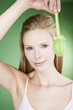 A young blonde woman holding a green Easter egg