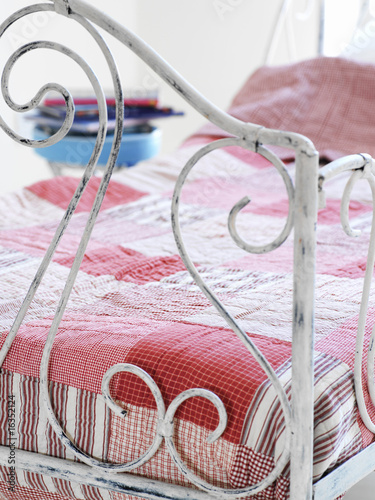 Photo: Bed covered with patchwork quilt Bed covered with patchwork quilt