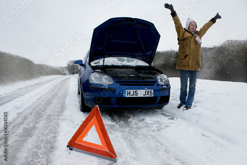 Foto: Stranded woman flagging down car in snow Stranded woman flagging down car in snow
