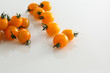 Kirschtomaten gelb auf weissem Acryl mit Wassertropfen