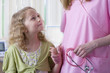 Smiling girl holding hands with nurse holding stethoscope