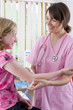 Smiling nurse holding syringe and preparing to give girl an injection