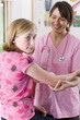 Smiling nurse holding syringe and preparing to give worried girl an injection