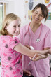 Smiling nurse holding syringe and preparing to give girl an injection