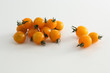 gelbe Kirschtomaten auf weissem Acryl mit Wassertropfen