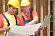 Foto: two workers with a notebook on a construction site two workers with a notebook on a construction site