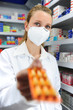 pharmacist with mask selling medicine