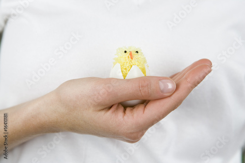 Photo: A woman holding an Easter chick toy, close-up A woman holding an Easter chick toy, close-up