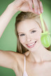 A young blonde woman holding a green Easter egg