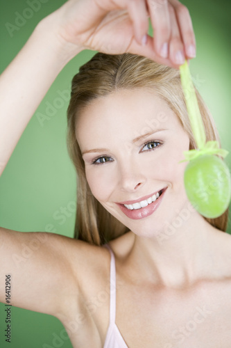 Photo: A young blonde woman holding a green Easter egg A young blonde woman holding a green Easter egg