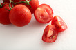 Strauchtomaten rot auf weiss mit Wassertropfen,