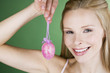 A portrait of a young blonde woman holding a pink Easter egg