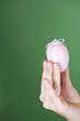 A woman holding a pink Easter egg, close-up