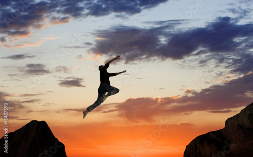 Photo: Man Leaping Mid-air on Mountainside Man Leaping Mid-air on Mountainside