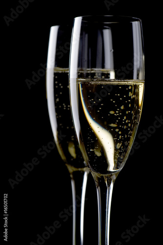 Photo: Two glasses champagne on black close up Two glasses champagne on black close up