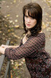 junge brunette frau mit gepunkteter bluse im herbst