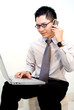 Asian business male multitasking - phone and laptop