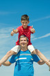 child in a red shirt sitting on his father child in a red shirt sitting on his father