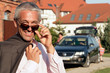 Handsome mature businessman standing before house