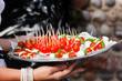 Waitress serving cherry tomatoes with feta cheese and quail eggs