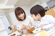 朝食時にご飯を食べる母親と息子
