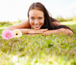 Lovely young female lying on grass field