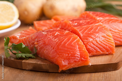 Photo: three salmon pieces on a chopping board three salmon pieces on a chopping board