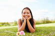 Happy cute female lying isolated at the park