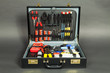 Leather suitcase with tools against a dark background