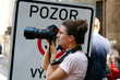 Foto: junge Frau beim Fotografieren vor einem Gefahrenschild junge Frau beim Fotografieren vor einem Gefahrenschild
