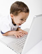 A young boy playing on a laptop computer A young boy playing on a laptop computer