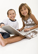 Photo: Two young kids playing on a laptop computer Two young kids playing on a laptop computer