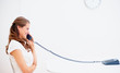 Happy young woman speaking over a land line telephone