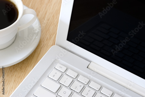 Photo: White laptop and coffee cup White laptop and coffee cup