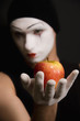 Mime with red apple on black background
