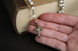 Hand mit Rosenkranz und Bibel