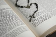 Buch aufgeschlagen mit Rosenkranz