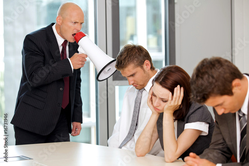 Photo: Young confident caucasian businessman screaming on his employee Young confident caucasian businessman screaming on his employee