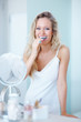 Cute young female brushing teeth