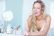 Young blond brushing her teeth