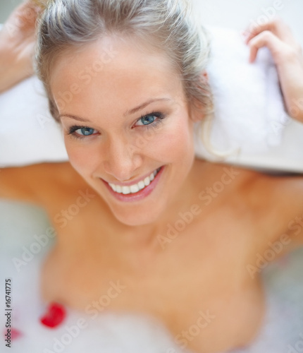 Photo: Closeup portrait of a happy young female having a bath Closeup portrait of a happy young female having a bath