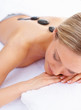 Closeup of a female pampering herself with a stone massage thera