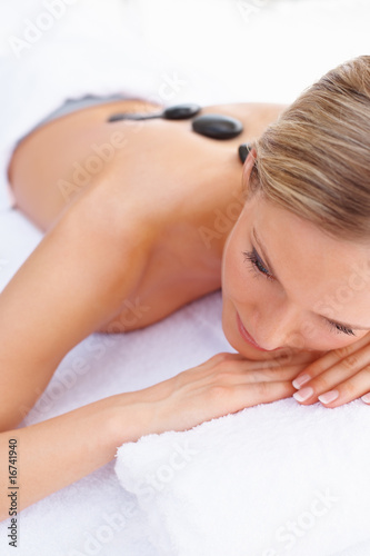 Foto: Closeup of a female getting a stone massage therapy Closeup of a female getting a stone massage therapy