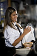 Photo: Hispanic female bartender drying wine glass Hispanic female bartender drying wine glass