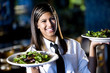 Photo: Hispanic waitress serving two plates of salad in a restaurant Hispanic waitress serving two plates of salad in a restaurant