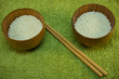 bowls with rice and sticks on green mat bowls with rice and sticks on green mat