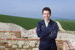 Smiling bricklayer standing next to brick wall