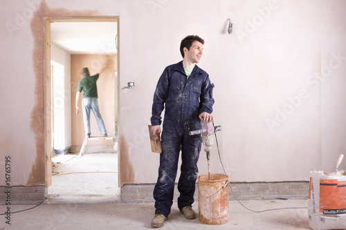 Photo: Man mixing plaster in house under construction Man mixing plaster in house under construction