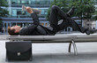 young caucasian businessman lying on bench reading newspapper